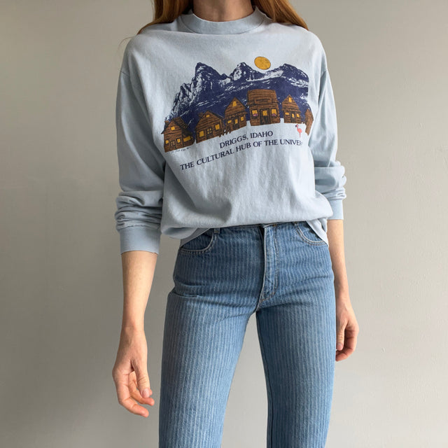 1980s Driggs, Idaho - Le centre culturel de l'univers - T-shirt en coton à manches longues